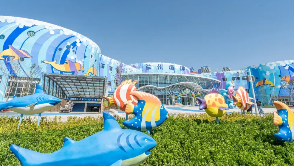 兰州极地海洋世界，巨大的水族箱内色彩斑斓的热带鱼和珊瑚礁，游客在透明的海底隧道中观赏海洋生物